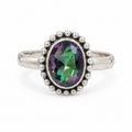 A sterling silver ring featuring an oval-cut iridescent gemstone with green, purple, and blue flashes, surrounded by a beaded halo and a textured silver band.